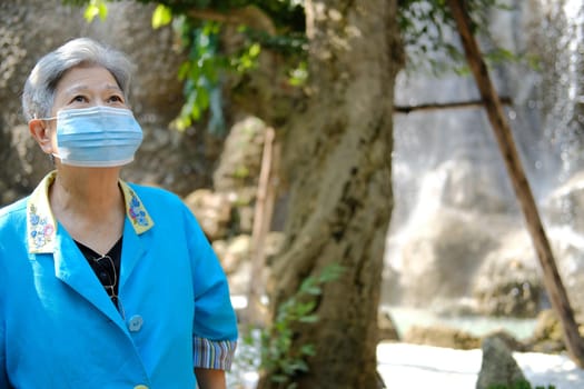 asian old elderly elder woman wearing facial mask resting relaxing in garden. senior leisure lifestyle