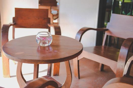 glass bowl with flower floating on water decorating on wooden table in living room