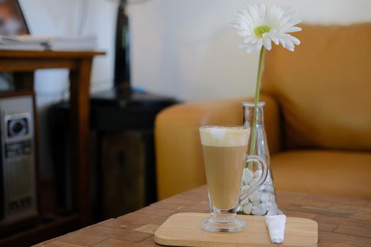 artificial white gerbera flower with hot latte cappuccino mocha coffee.
