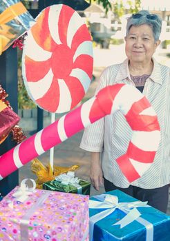 asian old elder woman elderly senior with decorative gift present box at christmas