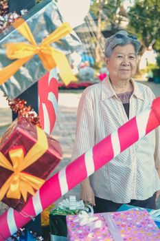 asian old elder woman elderly senior with decorative gift present box at christmas