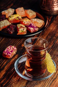 Tea in armudu glass with oriental delight rahat lokum over wooden surface