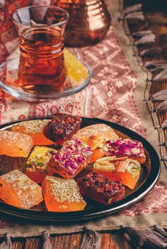 Oriental delight rahat lokum with tea in armudu over tablecloth with ornament