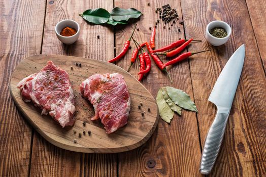 Meat with some condiment on kitchen table. Ready for cooking.