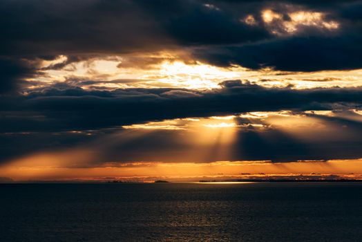 Sunrise on river. Sunbeams make a way through the clouds