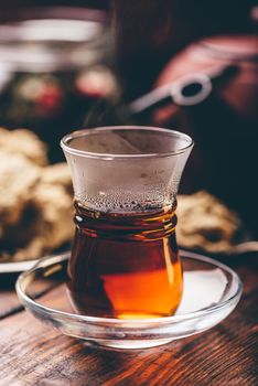 Armudu glass with black tea with kitchenware on background