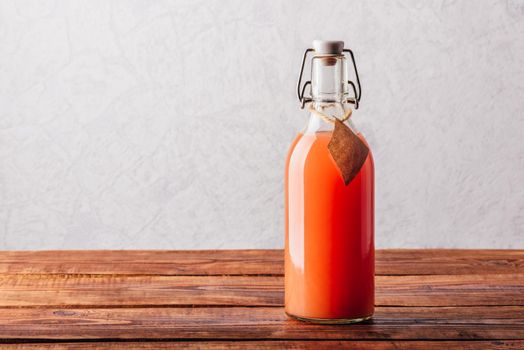 Bottle of grapefruit juice on wooden surface