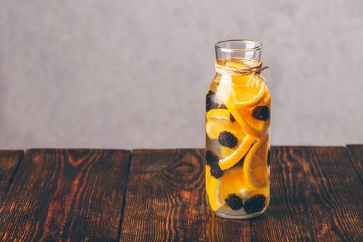 Bottle of Detox Water Infused with Sliced Raw Orange and Fresh Blackberry.