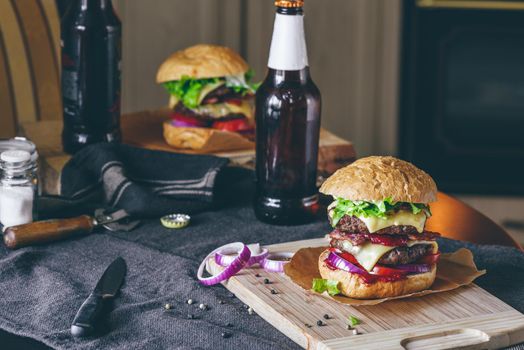 Dinner with Two Patties Cheeseburger and Couple Bottle of Beer on Kitchen Table.