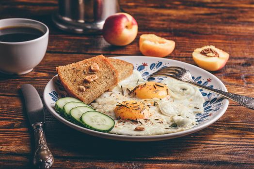 Breakfast toast with fried eggs with vegetables on plate and cup of coffee with fruits over dark wooden background. Healthy, clean eating, dieting food concept.