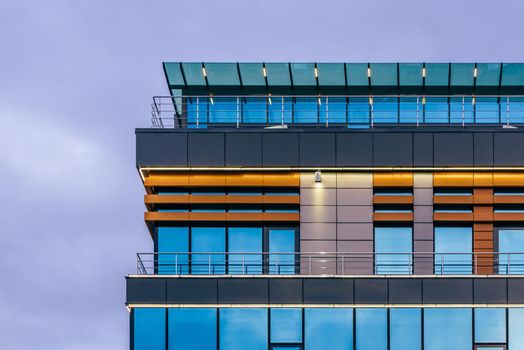 Modern high-rise office building with a glass facade at overcast, background.