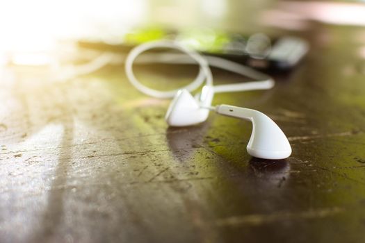 White earphone on desk with soft light