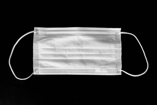 Disposable surgical mask on black background