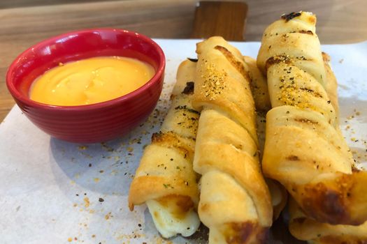 Bread stick with dip cheeses on a board in restaurant