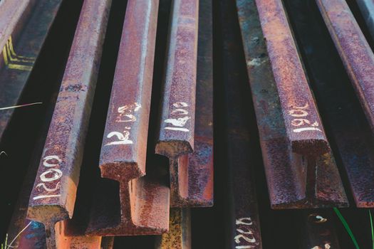 Steel tracks piled together beside the tracks