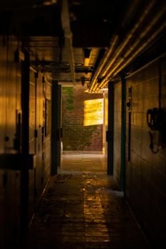 A Dark Hallway Inside an Abandoned Dormatory With Orange Light at the End of It