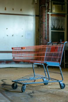 A Red Shopping Cart In a Large Empty Room in a destroyed Abandoned Building