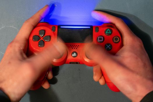 December 5, 2020 - Elkins Park, Pennsylvania: A Red PS4 Controller With Motion Blur Over the Thumbsticks Showing the Controller Being Used