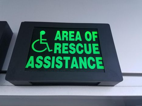 a green area of rescue assistance sign with wheelchair