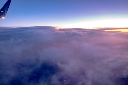 flying over rockies in airplane from salt lake city at sunset