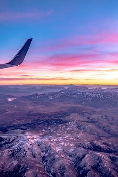 flying over rockies in airplane from salt lake city at sunset