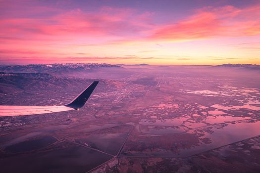 flying over rockies in airplane from salt lake city at sunset