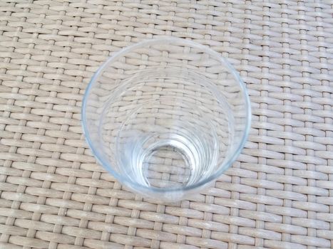 tall clear drinking glass on brown wicker table