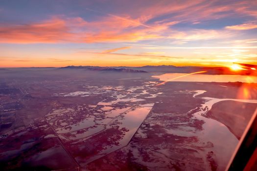 flying over rockies in airplane from salt lake city at sunset