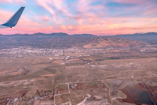 flying over rockies in airplane from salt lake city at sunset