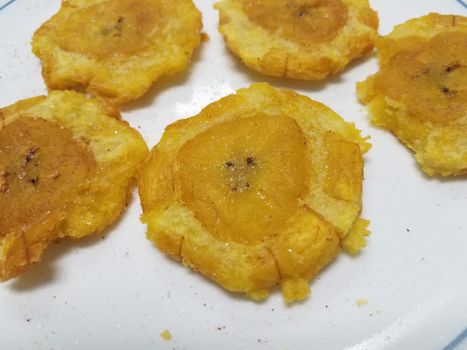 Puerto Rican flat plantains with salt called tostones, on a white plate