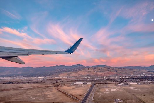 flying over rockies in airplane from salt lake city at sunset