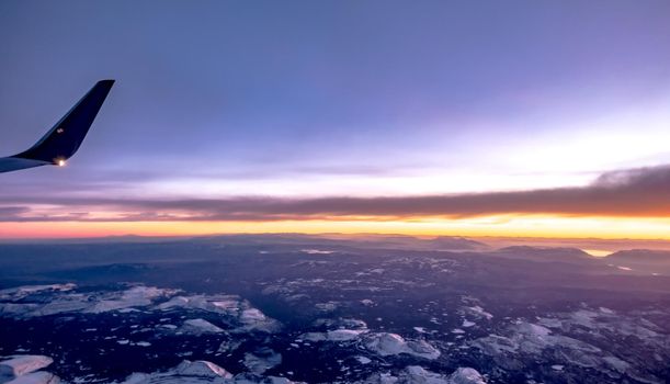 flying over rockies in airplane from salt lake city at sunset