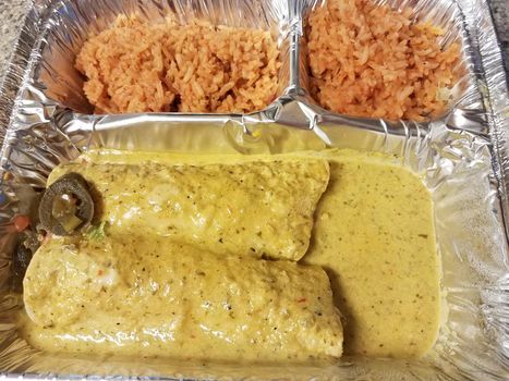 enchilidas with salsa and rice and peppers in metal tray
