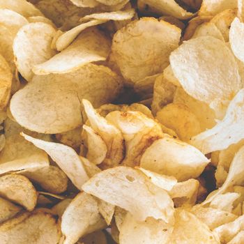 Rustic chips golden pattern. Crispy chips background. Yellow salted potato chips as background. Retro style food photo.