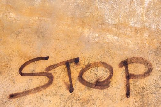 The word Stop written on the orange vintage wall