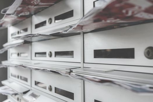 Modern mailboxes filled of flyers. Business and advertising concepts. Shallow depth of field.