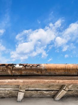 Rusted gutter. Broken gutter on an old roof. Blue sky for copy space on background.