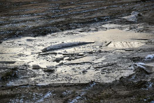 Wet mud puddle in a field after a rain