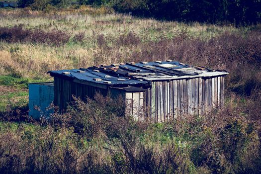 Old weathered wooden hut in the middle of the field