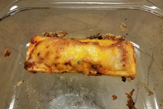 a cheese enchilada with sauce in a glass pan