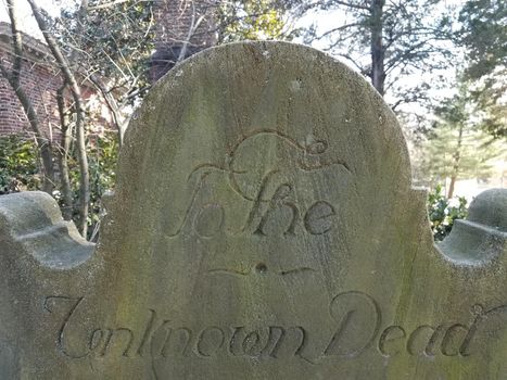 old tombstone with engraving or carving to the unknown dead