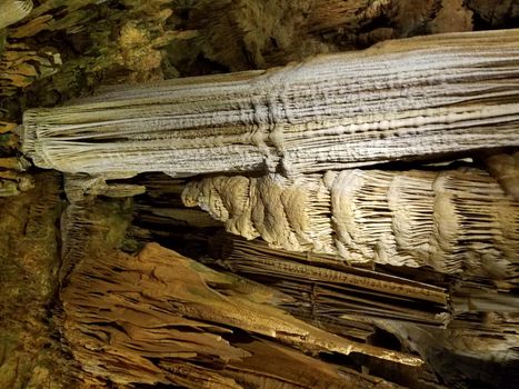 brown stalactites and stalagmites in a cave or cavern