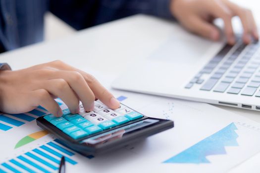 Hand of young asian business man working using calculator for planning accountant, graph for finance and report statistics, investment and profit of income, businessman analyzing with chart.