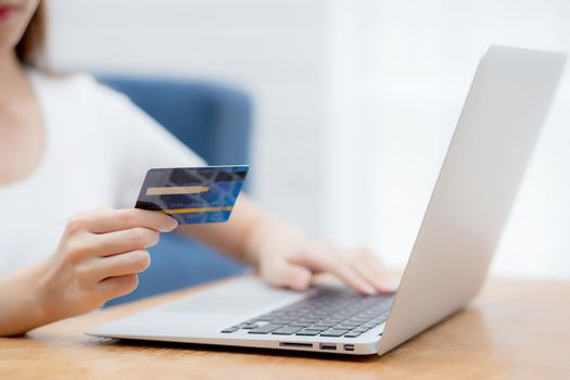 Hand of young woman holding credit card buying shopping online with laptop computer, girl purchase and payment on internet, commerce and e-business, transaction for finance, business concept.