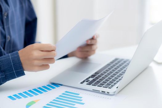 Hand of young business man looking document data graph and chart paper, marketing and investment, report of statistics profit for financial, economic and growth of finance, management and planning.