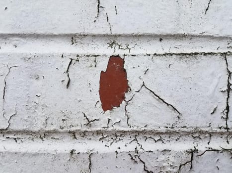 old and weathered brick wall with white paint