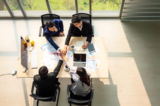 Top view on a group of businessman and businesswoman having a meeting and making a business commitment.