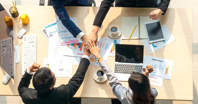 Top view on a group of businessman and businesswoman having a meeting and making a business commitment.