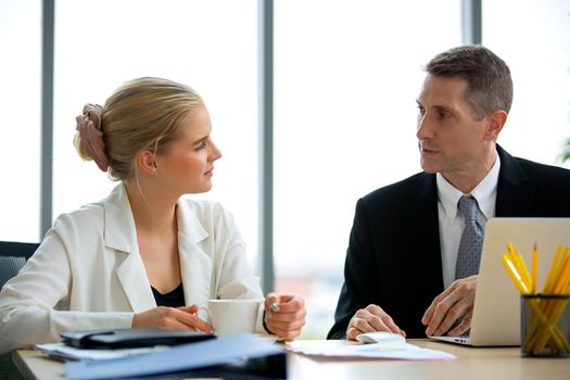 young business team working together at office. Manager pointing at a chart and explaining the analysis about business strategies. Top view shot of business hand shake