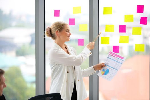 young business team working together at office. Manager pointing at a chart and explaining the analysis about business strategies. Top view shot of business hand shake